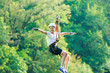 © Natali - Happy, cute, young boy in white t shirt and helmet having fun and playing at adventure park, holding ropes and climbing wooden stairs. active lifestyle concept