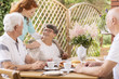 © Photographee.eu - Smiling elderly woman and caregiver while eating breakfast with friends