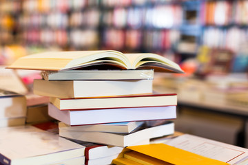 stack of books lying on table in bookstore