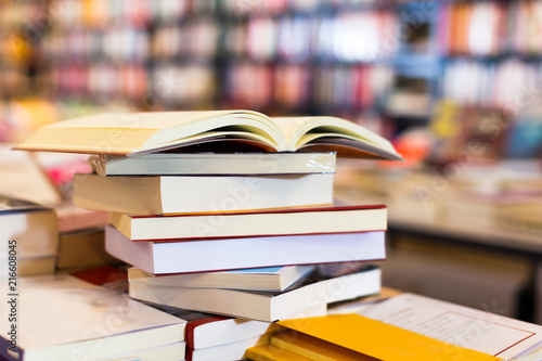 stack of books lying on table in bookstore Poster Mural XXL