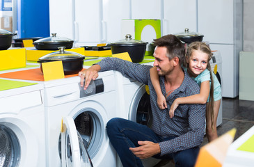 dad shopping in household department in hypermarket with daughter