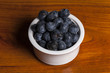 © dohee - blue barry on the white ceramic, wood table, grey background.