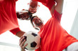 © pressmaster - Three young footballers standing head to head close to each other symbolizing unity