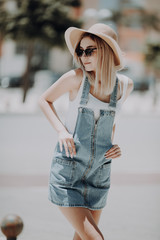 Wall Mural - Portrait of young pretty trendy girl posing at the city in Europe, summer street fashion.