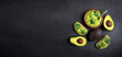 Traditional Mexican Dip Sauce Guacamole in a bowl with bread toasts,  whole and cut half avocado  on dark background. Top view. Copy space.