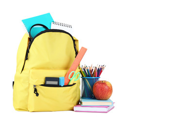 Yellow backpack with school supplies on white background