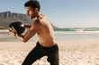 © Jacob Lund - Man training at the beach using a medicine ball