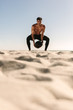 © Jacob Lund - Man training at the beach using a medicine ball