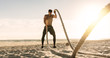 © Jacob Lund - Man doing workout using battling ropes at the beach