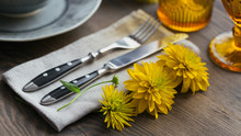 Rustic Table Setting With Linen Napkin, Cutlery, Ceramic Plates, Yellow Glasses And Yellow Flowers
