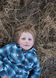 © Connect Images - Boy lying in dry grass, portrait
