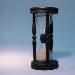 Wall Mural - closeup of hourglass. isolated on blue background.