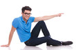 © Viorel Sima - happy seated casual man is pointing to side