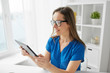 © Syda Productions - business, people and technology concept - happy smiling middle-aged woman in glasses with tablet pc computer working at home or office