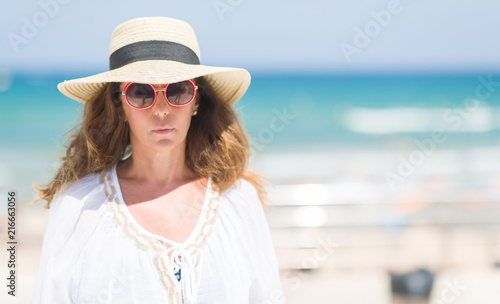 Middle Age Brunette Woman Wearing Summer Hat On Vacations By The