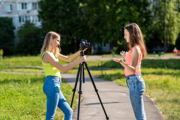 Two girls schoolgirl. Summer in the city. Record the broadcast. Record vlog and blog. Record video lesson for Internet. Use camera with tripod.