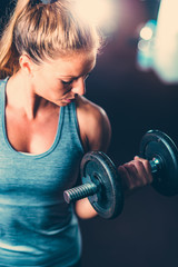 Female athlete exercising with dumbbells