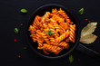 Homemade Fusilli pasta with bolognese sauces in the black iron pan on black slate board background