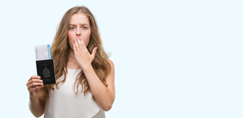 Wall Mural - Young blonde woman holding passport of canada and boarding pass cover mouth with hand shocked with shame for mistake, expression of fear, scared in silence, secret concept