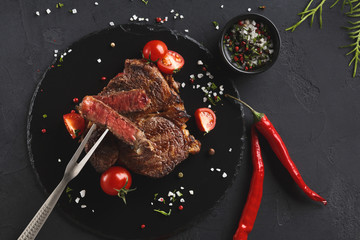 Wall Mural - Rare rib eye steak on dark plate, top view