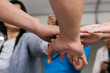 © twinsterphoto - Close up of young business people putting their hands together for unity. Hands stacking over for collaboration and teamwork
