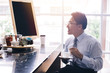 © twinsterphoto - Asian smart businessman as male customer drinking coffee at cafe restaurant