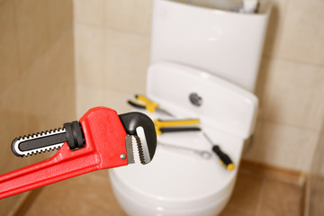 Canvas Print - Pipe wrench near toilet indoors. Plumber's tools