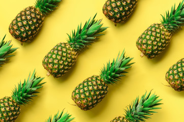 Wall Mural - fresh pineapples on yellow background. top view. pop art design, creative concept. copy space. brigh