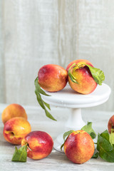 Wall Mural - Many juicy beautiful amazing nice peaches on light wooden background. Beautiful food art background.