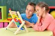 © aletia2011 - little boy and girl sitting at table and counting on abacus
