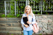 © Andrii - Enthusiastic Happy beautiful young girl smiling and holding pile of books standing near campus lifestyle positivity academic graduating university school