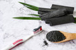 © ronnarong - Toothpaste by activated charcoal powder on marble table