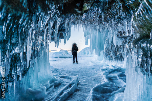 Fotomural Travelling in winter, a man standing on Frozen lake Baikal with Ice cave in Irk