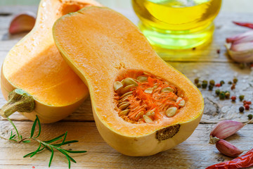 Wall Mural - Raw organic butternut squash with ingredients for cooking on a wooden table. Selective focus