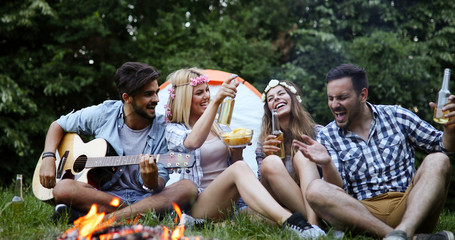 Group of friends listening to guy playing the guitar