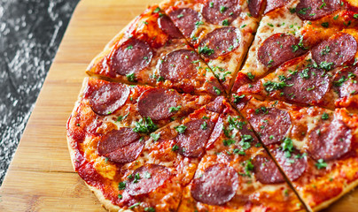 sliced Pepperoni Pizza with Mozzarella cheese, salami, Tomatoes, pepper, Spices and Fresh Basil. Italian pizza