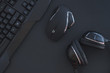 Black mouse, the keyboard, the headphones are isolated on a dark background, the top view. Flat lay gamer background. Workplace with a keyboard, mouse and headphones on a black background. Copyspace