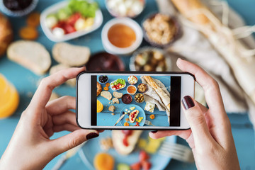 Woman taking a photo of breakfast table