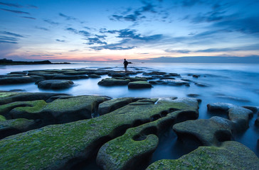 Wall Mural - sunset seascape with beautiful rocks formation covered by green moss. soft focus due to long expose. s