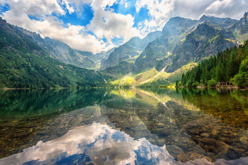 Wall Mural - Beautiful alpine lake in the mountains, summer landscape with blue cloudy sky and reflection in crystal clear water, natural background, Morske Oko (Eye of the Sea), Tatra Mountains, Zakopane, Poland