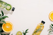 Leaves and bottle tropical water on white background. Detox fruit infused water, citrus fruits and rosemary leaves. Top view, flat lay, copy space