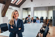 © bnenin - Portrait of successful female business leader. Colleagues in the background.