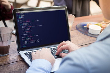 man coding and programming for web development and web design concept using laptop / computer. codin