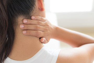 closeup woman neck and shoulder pain and injury. health care and medical concept.