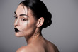 portrait of beautiful girl with black lips and freckles posnig for fashion shoot, isolated on grey