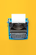 © BigBlueStudio - Typewriter machine in retro style on yellow background. Top view.