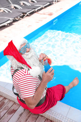 Wall Mural - Authentic Santa Claus with cocktail near pool at resort