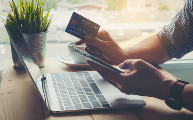 Man holding credit card payment shopping online on smart phone