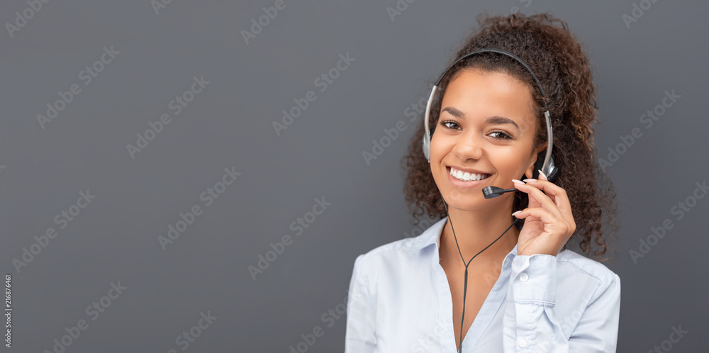 Call center employee isolated on a gray background. - obrazy, fototapety, plakaty 