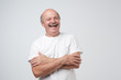 Mature adult man with moustache laughing looking at the camera over white background.